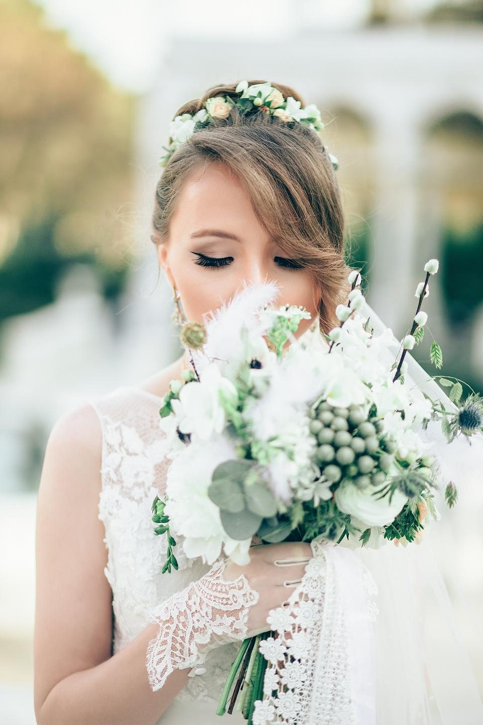 Mariée tenant un bouquet blanc et vert sous lumière dorée — mariage été 2026 You Rêve Paris