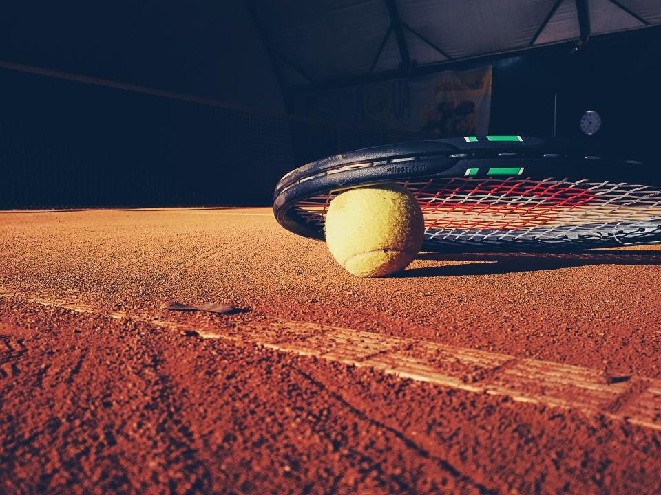 Raquette et balle sur court de terre battue — Roland-Garros 2026 You Rêve Paris